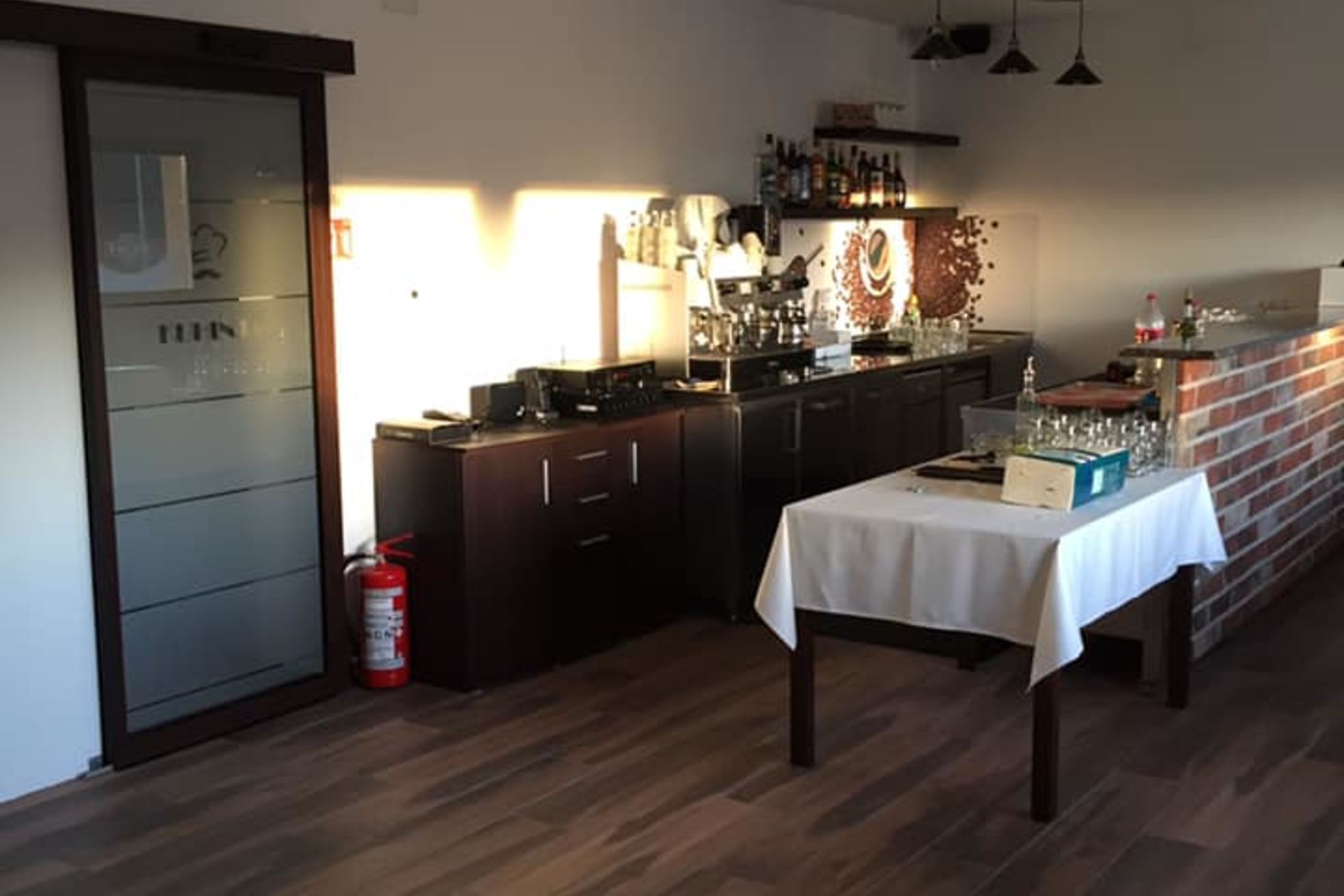 Unutrašnjost Bistroa Lučice s ciglenim zidom i postavljenim stolom